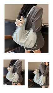 Détail du sac hobo en cuir souple bleu clair avec un adorable charm d'ours blanc