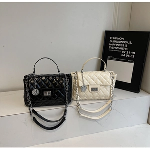 Detail of quilted leather crossbody bags with silver chain straps and metallic turn-lock
