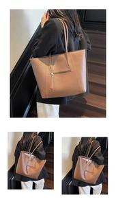 Detail showing the brown faux leather tote bag with stylish decorative zipper on front