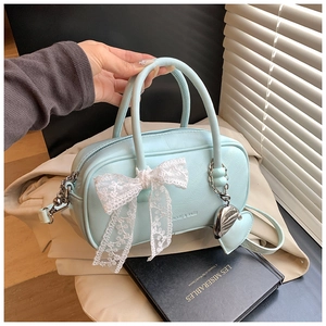 Détail du sac bowling bleu menthe avec grand nœud en dentelle et pendentif cœur