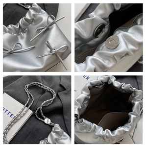 Detail view of silver bow tote bag showing chain strap, magnetic closure and inner lining
