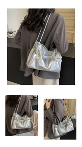 Detailed view of silver metallic tote bag with MIKAQI embossed logo and plush charm