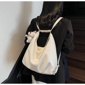 Sac à dos minimaliste en cuir souple blanc crème avec breloque chien et plis doux