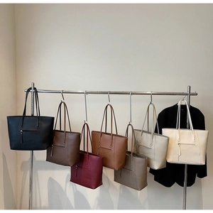 Detailed view of six solid color leather tote bags with convenient back zipper pockets