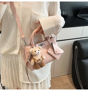 Détail du sac bandoulière rose montrant le fermoir en métal, l'ourson et le petit porte-monnaie