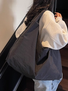 Minimalist large black nylon tote bag for women showing relaxed slouchy shoulder carry