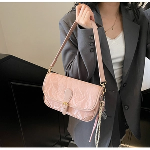 Nahaufnahme der rosa Kunstledertasche mit goldener Schnalle an einem grauen Anzug