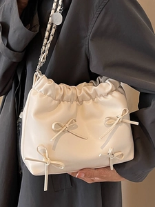 Creamy soft leather tote bag with chain strap and bow details shown on model