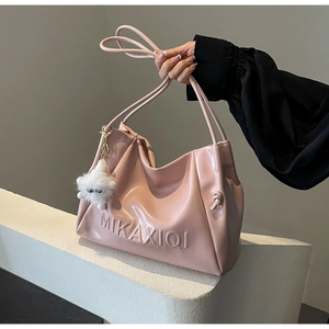 Detail of pink faux leather tote bag with cloud pleats and cute white cat plush charm