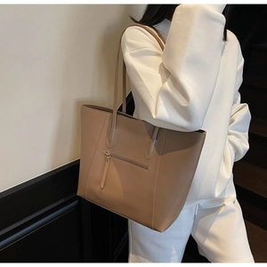 Detailed view of large tote bag back featuring a practical zipper pocket and leather texture