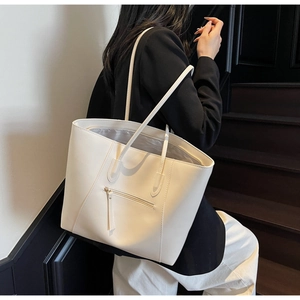 Minimalist cream white tote bag with large capacity and front zipper detail shown on shoulder