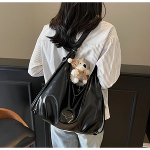 Détail du sac hobo en cuir souple noir avec un joli pendentif ours en peluche blanc