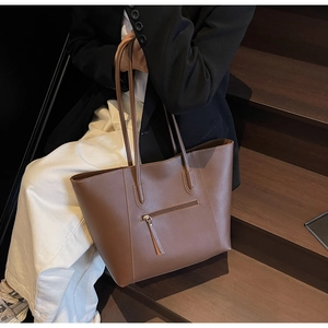 Detail of the side zipper pocket and stitching on a dark coffee large tote bag
