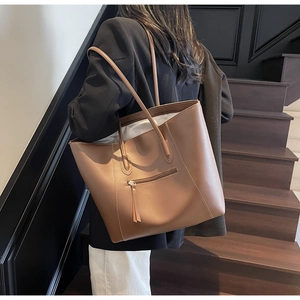 Detailed close-up of brown large capacity tote bag featuring a front horizontal zipper pocket