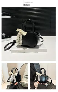 Close-up of black glossy mini tote bag featuring a white lace bow and metal hardware