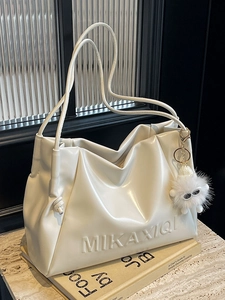 Minimalist cream white soft leather tote bag with monster charm and side knot detail