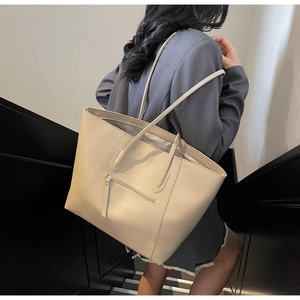 Detailed view of cream-colored large tote bag with zipper pocket on modern stairs