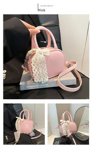 Pink faux leather crossbody bag detail with delicate white lace bow and silver hardware