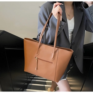 Detail view of the brown PU leather tote bag with back zipper pocket and tassel pull