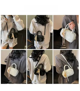 Detailansicht der Mini-Boston-Tasche mit geometrischer Prägung und Streifen-Quaste