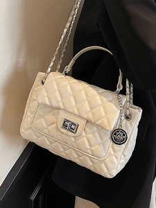 Elegant cream quilted leather crossbody bag with chain strap and metal lock detail