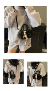 Detailansicht einer schwarzen PU-Ledertasche mit stilvollem, buntem Webanhänger