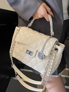 Elegant cream quilted crossbody bag with silver chain strap and polished metal lock
