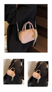 Detailansicht der rosa Graffiti-Handtasche mit goldener Hardware und Fransen-Anhänger