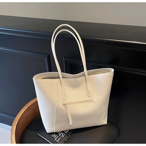 Detail of creamy white tote bag with hidden front zipper pocket and long shoulder straps