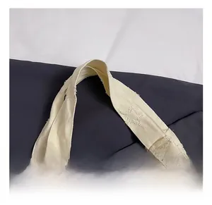 Detail of frayed star pattern on cream canvas tote bag with sturdy handles