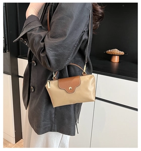 Mini nylon dumpling bag detail with contrast leather flap and golden snap button closure