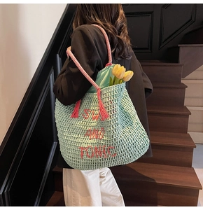 Detail of mint green woven tote with pink rope handles and red Sweet and Tonic text