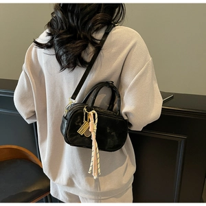 Details der schwarzen Mini-Boston-Tasche mit Graffiti-Textur und buntem Schal-Zubehör