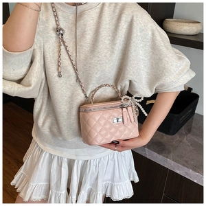 Pink quilted mini box bag with silver hardware and pearl bow charm shown on model