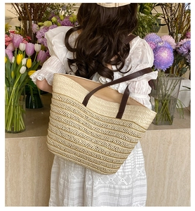 French style straw tote bag with brown leather straps shown in a fresh flower shop setting