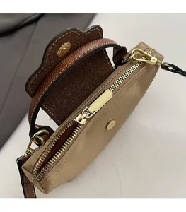 Detail of smooth gold zipper and contrast stitching on nylon hobo crossbody bag