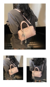 Detailed close-up of pink PU leather Boston bag with embossed text and metal zipper
