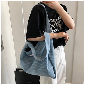 Detail view of the light blue corduroy tote bag showing the vertical ribbed texture and slouchy shape