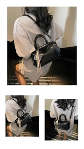 Detail of black glossy leather bowling bag with embossed letters and tennis racket charm