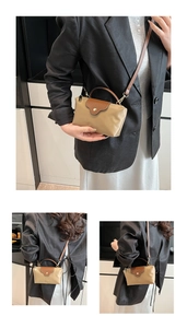 Detail view showing a mini nylon crossbody bag in khaki and brown leather contrast