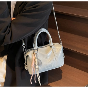 Light blue-grey leather Boston bag with embossed lettering and braided charm pendant