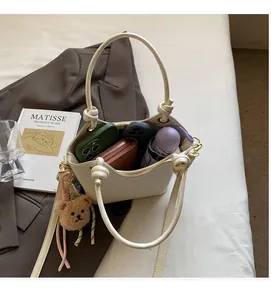 Capacité intérieure du sac seau beige en PU montrant téléphone, portefeuille et parapluie