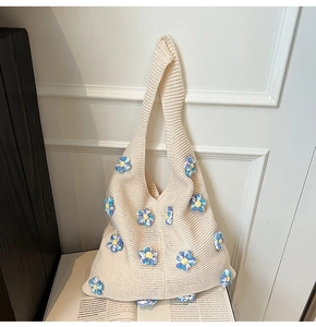 Détail d'un sac cabas en maille crochetée à fleurs avec une finition tissée crème