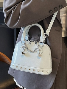Borsa a conchiglia in pelle verniciata azzurra con borchie, catena e ciondolo a dado
