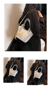 Détail du sac seau argenté avec texture perlée, breloque d'ours et pompon doux