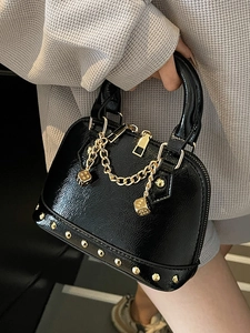Borsa a mano nera lucida con borchie, catena dorata e ciondoli a dado stile elegante