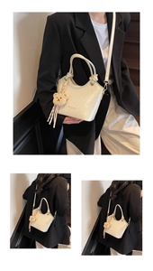 Détail d'un sac seau blanc crème avec une texture fine et un joli charm d'ours en peluche