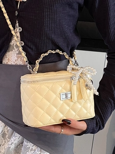 Fashionable quilted cream crossbody bag with chain strap and pearl bow detail charm
