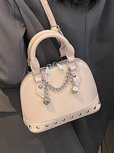 Borsa a tracolla rosa chiaro a forma di conchiglia con rivetti argentati e dadi