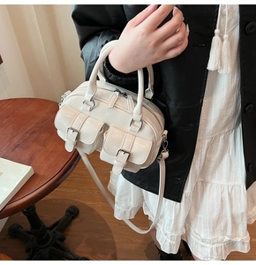 Détail du sac Boston en cuir ciré crème avec boucles argentées et design multi-poches